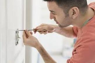 man installing light switch